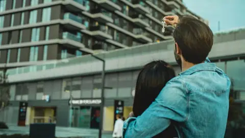 Para z kluczykami przed apartamentowcem